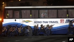 Police and SWAT members assault a tourist bus to rescue hostages at Manila's Rizal Park Monday, 23 Aug 2010
