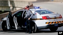 FILE - A Pennsylvania state trooper stands beside his vehicle parked on the entrance ramp to Interstate 376 out of Pittsburgh, June 26, 2018.