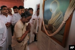 India's opposition candidate for the Presidential election Meira Kumar pays respects in front of a portrait of Mahatma Gandhi during her visit to Gandhi Ashram before the start of her campaign in Ahmadabad, India, Friday, June 30, 2017.