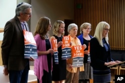 FILE - Marilyn Balcerak, right, of Bonney Lake, Wash., speaks at a news conference in Bellevue, Wash., in support of Initiative 1491, which would allow family members and law enforcement officials to petition a judge to temporarily suspend a person's access to weapons.