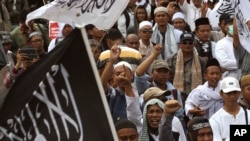 Para pendukung dan anggota Hizbut Tahrir Indonesia (HTI) mengadakan aksi protes menentang keputusan Presiden Joko Widodo untuk membubarkan HTI, di Jakarta 18 Juli 2017.