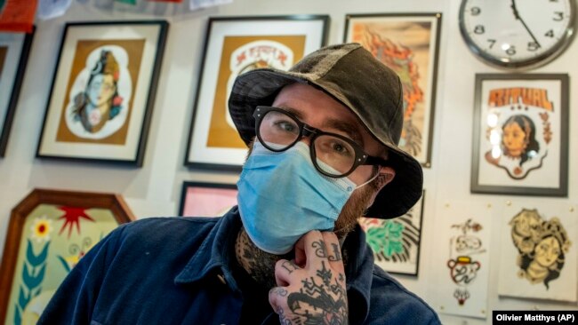 Owner and artist, Roman Castelvechi poses for a photo in his tattoo store in Brussels, on March 4, 2021. (AP Photo/Olivier Matthys, File)