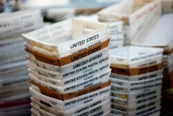 FILE- In this Dec. 14, 2017, photo, boxes for sorted mail are stacked at the main post office in Omaha, Neb.