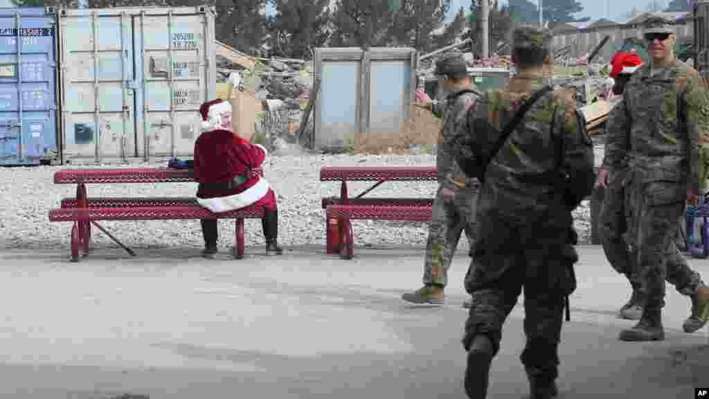 A U.S. soldier dressed as Santa Claus waves to fellow troop son Christmas day at the U.S. air base in Bagram, north of Kabul, Afghanistan, Dec. 25, 2015. 