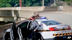 ARCHIVO - Un patrullero estatal de Pennsylvania junto a su vehículo a la entrada de la rampa que conduce a la autopista interestatal 376 saliendo de Pittsburgh. Junio 26, 2018.