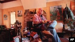 FILE - Ram Dass, the counterculture spiritual leader best known for the 1971 bestseller "Be Here Now," sits inside his home in San Anselmo, California, Oct. 21, 1998. 