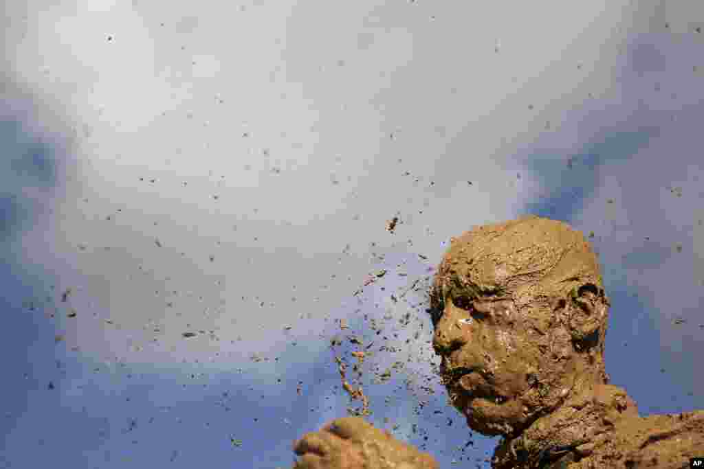 An Iranian mourner covers his head with mud during Ashura rituals, marking the death anniversary of Imam Hussein, the grandson of Islam&#39;s Prophet Muhammad, at the city of Bijar, west of the capital Tehran.