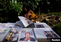 Seorang penjual koran dengan berbagai koran di Jakarta, 10 November 2016. (Foto: Reuters)