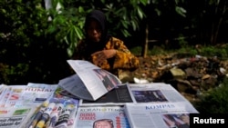 Seorang penjual koran dengan berbagai koran di Jakarta, 10 November 2016 sebagai ilustrasi. (Foto: Reuters)