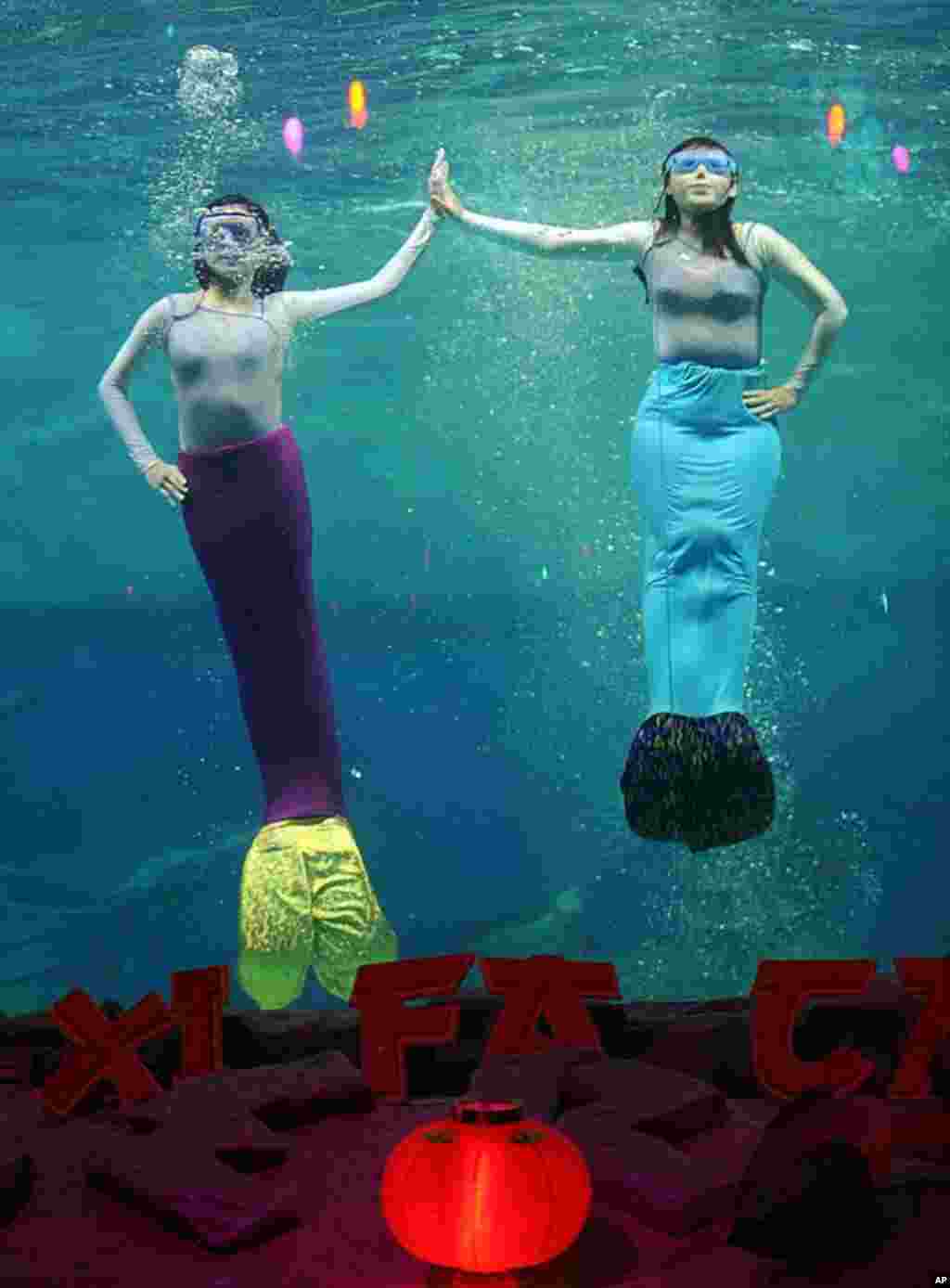 People perform during an underwater theater show celebrating Chinese New Year in the Ancol park in Jakarta, January 23, 2012. (AFP)