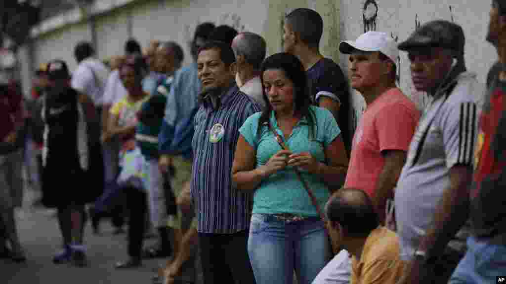 People wait in line to vote in general elections outside a school at the Mare Complex slum in Rio de Janeiro, Brazil, Oct. 26, 2014.