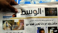 FILE - A man picks up a copy of Al Wasat newspaper at a news stand in Hamad Town, Bahrain, on Tuesday, April 5, 2011. 