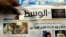 FILE - A man picks up a copy of Al Wasat newspaper at a news stand in Hamad Town, Bahrain, on Tuesday, April 5, 2011. 