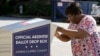 FILE - In this Oct. 19, 2020 file photo, a voter drops their ballot off during early voting in Athens, Ga. 