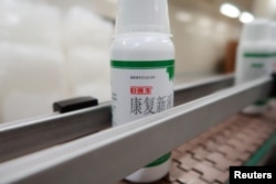 Bottles of a liquid medicine made of cockroaches, are seen on the production line at a facility operated by pharmaceutical company Gooddoctor in Xichang, Sichuan province, China August 10, 2018. Picture taken August 10, 2018. REUTERS/Thomas Suen