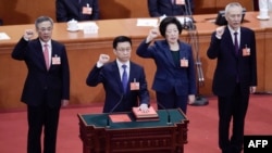 Les vice-Premiers ministres Hu Chunhua, à gauche, Sun Chunlan (2e à droite) et Liu He (à droite), nouvellement élus, prêtent serment au Grand Palais du Peuple, à Pékin, le 19 mars 2018. 