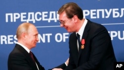 FILE - Russian President Vladimir Putin, left, shakes hands with Serbian President Aleksandar Vucic in Belgrade, Serbia, Jan. 17, 2019.