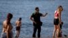 Polisi memperingatkan orang-orang untuk tidak duduk-duduk di pantai Barcelona saat Spanyol mulai melonggarkan pembatasan terkait Covid-19. 