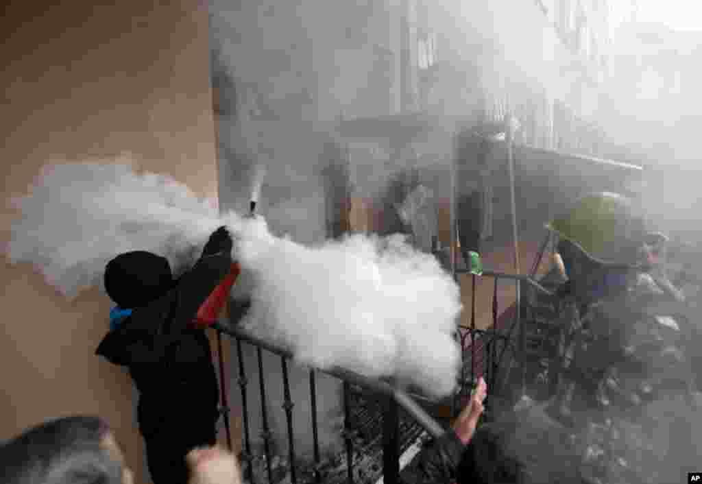 A pro-Russian protester shoots off a fire extinguisher aiming at riot police inside a police station in Odessa, May 4, 2014.