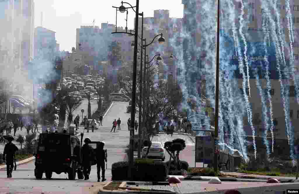 Israeli forces fire tear gas canisters at Palestinian protesters during clashes near the Jewish settlement of Beit El, in the Israeli-occupied West Bank.