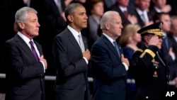 From left, outgoing Defense Secretary Chuck Hagel, President Barack Obama, Vice President Joe Biden and Joint Chiefs Chairman Gen. Martin Dempsey listen to the national anthem during a tribute to Hagel at Fort Myer in Arlington, Virginia., Jan. 28, 2015.