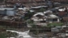 FILE - People walk along a bridge before a curfew which was ordered by the Kenya's President Uhuru Kenyatta to contain the spread of the coronavirus disease (COVID-19), within Kibera slums in Nairobi, Kenya, March 27, 2020. 