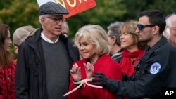 Aktris Jane Fonda (tengah), bersama aktor Ted Danson (bertopi), saat ditangkap pada protes iklim di gedung Capitol, Washington DC, Jumat (25/10).