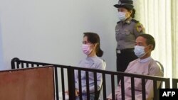 This handout photo taken on May 24, 2021 and released by Myanmar's Ministry of Information on May 26 shows detained civilian leader Aung San Suu Kyi (L) and detained president Win Myint (R) during their first court appearance in Naypyidaw, since the milit