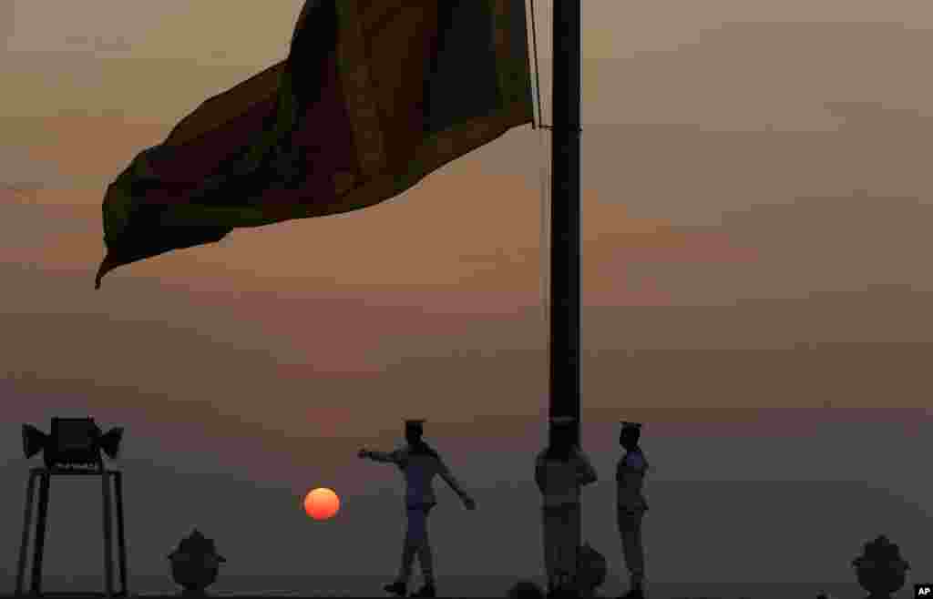 Navy sailors lower the Sri Lankan national flag as the sun sets on New Year&#39;s Eve in Colombo, Sri Lanka.