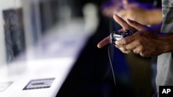 FILE - Show attendees play video games on the PlayStation 4 at the Sony booth during the Electronic Entertainment Expo in Los Angeles, June 13, 2013.