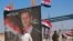 On Sept. 30, 2019, a man passes a poster of Syrian President Bashar Assad that reads, "Congratulations victory," at the newly opened crossing between the Iraqi town of Qaim and Syria's Boukamal, Syria.
