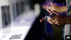 Show attendees play video games on the PlayStation 4 at the Sony booth during the Electronic Entertainment Expo in Los Angeles, June 13, 2013.