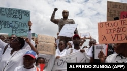 Membros da comunidade médica em Moçambique marcham em Maputo, junto à estátua Eduardo Mondlane, contra a violação dos direitos humanos no país