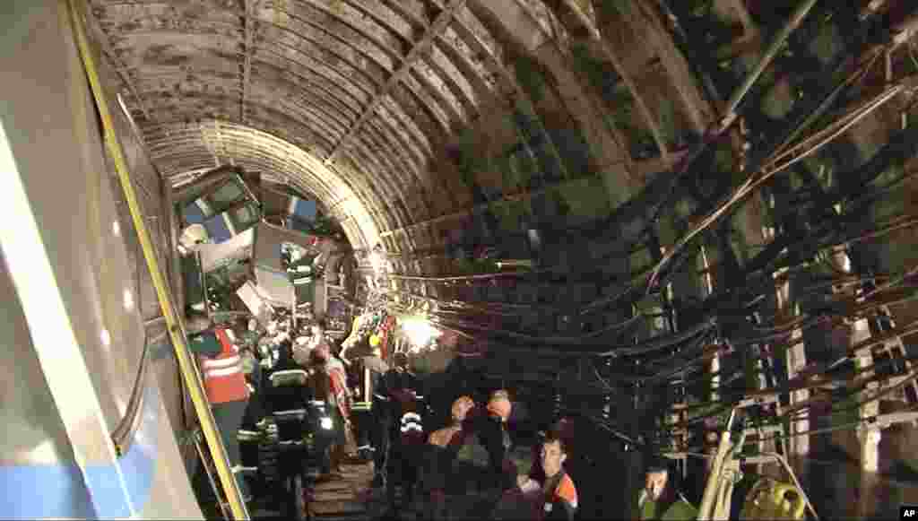 Rescue teams work inside the tunnel in Moscow where a rush-hour subway train derailed killing at least 20 people and sending 150 others to the hospital, Moscow, July 15, 2014.