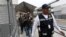 A security guard leads a group of U.S. asylum seekers out of Mexican immigration offices after they were returned by U.S. authorities to wait in Mexico under the so-called Remain in Mexico program, in Ciudad Juarez, Mexico, July 17, 2019.