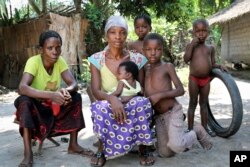 A family sits outside in a neighborhood where three people died of Ebola last month, in Mbandaka, Congo, June 1, 2018. For the first time since the Ebola virus was identified more than 40 years ago, a vaccine has been dispatched to front line health workers.