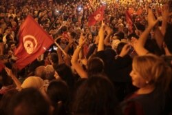 A crowd gathers on Tunis' main avenue, Oct. 13, 2019. Tunisian polling agencies are forecasting that conservative law professor Kais Saied has overwhelmingly won the North African country's presidential election.