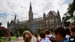 FILE - Prospective students tour Georgetown University's campus in Washington, D.C., July 10, 2013.