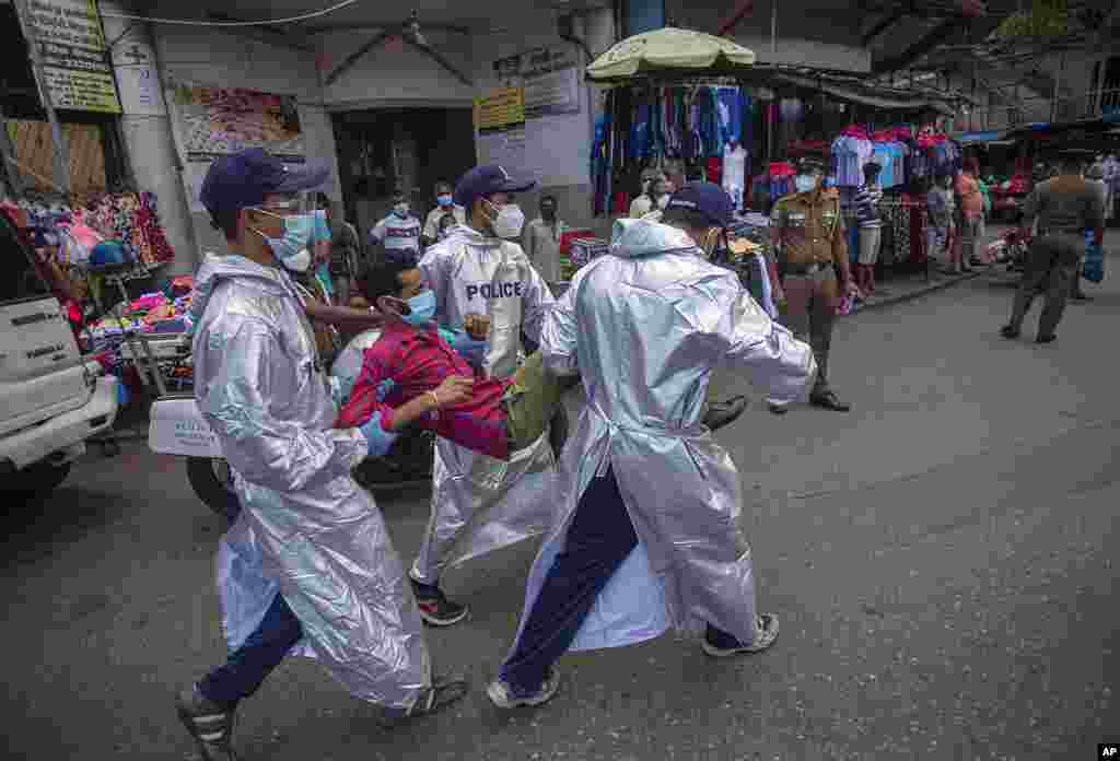 Sri Lankan police officials detain a man who violated the COVID-19 guidelines imposed by the authorities to curb the spread of the coronavirus in Colombo, Sri Lanka.