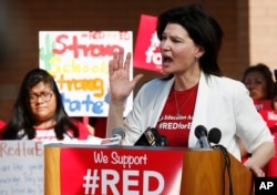 FILE - In this April 25, 2018 photo NEA President Lily Eskelsen Garcia speaks at the #RedForEd Walkout, March and Rally news conference in Phoenix, Arizona. Garcia challenged President Trump to sit in a classroom without health precautions.