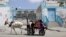 Palestinian children ride a donkey cart past a U.N. food distribution center in Khan Younis refugee camp, southern Gaza Strip, April 5, 2013.