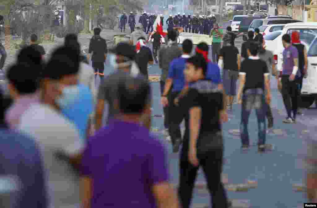 Anti-government protesters confront riot police during clashes in the village of Sanabis, west of Manama, Bahrain. 