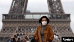 Une femme porte un masque de protection contre l'épidémie de coronavirus alors qu'elle marche sur l'esplanade du Trocadéro en face de la Tour Eiffel à Paris, France, le 1er février 2020. REUTERS / Gonzalo Fuentes - RC2ORE9D3SPA