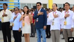 In this handout photo provided by the Tanuan City Information Office, Tanauan city Mayor Antonio Halili, third from right, attends a flag raising ceremony minutes before he was shot outside the municipal hall in Batangas province, south of Manila, Philipp