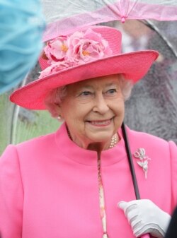 La reina Isabel II de Inglaterra habla a sus invitados en el jardín del Palacio de Buckingham, en Londres, el 10 de mayo de 2020.