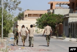 Fighters from the pro-government forces loyal to Libya's Government of National Unity (GNA) walk on August 3, 2016 in Sirte during an operation against jihadists of the Islamic State (IS) group.