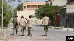 Des combattants des forces du gouvernement d'union nationale (GNA) patrouillent dans les rues de Sirte lors d’une opération contre le groupe Etat islamique, 3 août 2016. 