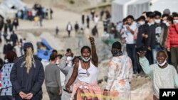 File: African migrant women shout "freedom" inside the new EU refugee camp of Kara Tepe in Mytilene, on Lesbos, on March 29, 2021.