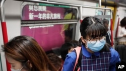 Commuters wear protection masks inside a subway train in Hong Kong, Jan. 7, 2020. 