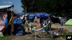 Seorang anak dari kaum migran beristirahat dari kamp migran yang dibangun seadanya, hanya terpaut beberapa meter dari perbatasan antara Serbia dan Hungaria (25/8). Horgos, Serbia. (foto: AP Photo/Darko Vojinovic)